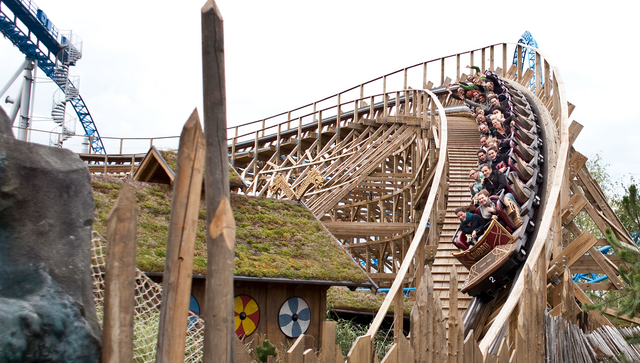 Eine Gruppe von Menschen f&auml;hrt Achterbahn in einem Erlebnispark.