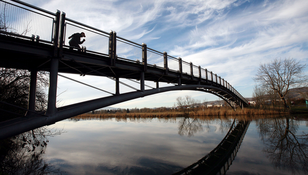 Ein Inlineskater fährt auf einer Fußgängerbrücke.