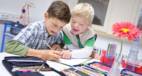Die Sch&uuml;ler Johannes (l.) und Felix (r.), ein Junge mit Down-Syndrom, sitzen in der Gemeinschaftsschule Gebhardschule in Konstanz an einem Klassentisch beim Malen. (Foto: &copy; dpa)