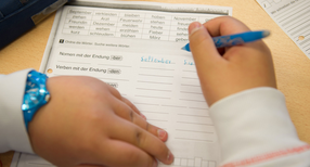 Eine ausl&auml;ndische Sch&uuml;lerin f&uuml;llt w&auml;hrend eines Deutschkurses ein Arbeitsblatt aus. (Foto: &copy; dpa)