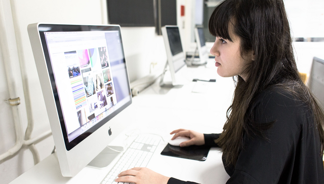 Eine Frau sitzt an einem Computer.