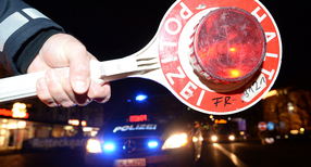 Eine Haltekelle der Polizei ist bei einer Kontrolle vor einem Polizeifahrzeug zu sehen. (Foto: &copy; dpa)