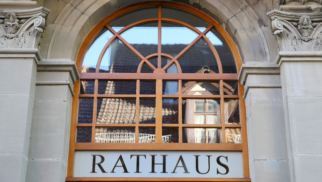 Über der Tür an einem historischen Gebäude steht „Rathaus“.