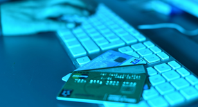 ILLUSTRATION - Auf einer Computertastatur liegen Kreditkarten.