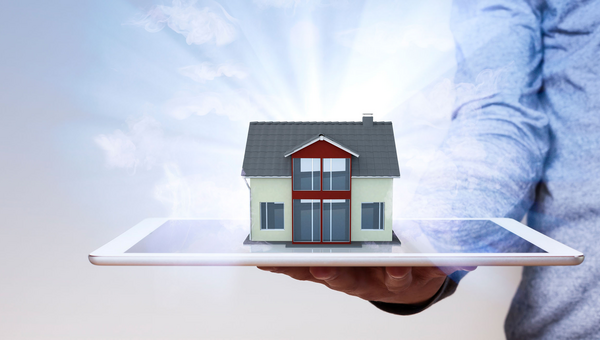 Ein Haus auf einem Tablet in der Hand eines Mannes.