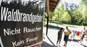 Ein Schild an einer Schutzh&uuml;tte im Wald weist auf Waldbrandgefahr hin.